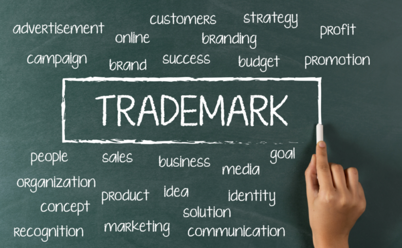 a hand drawing trademark on a chalk board with other words about business